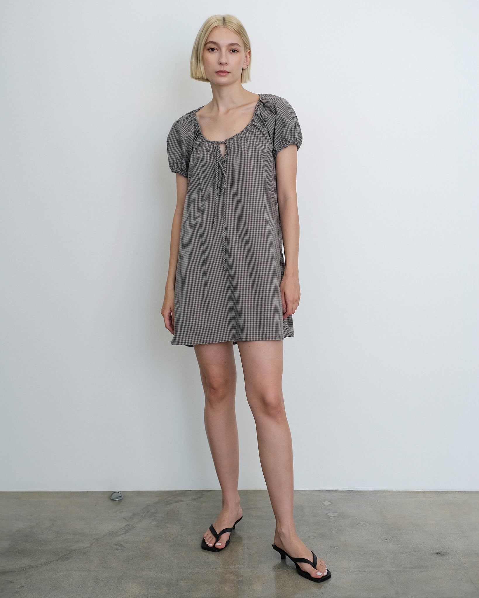 Model wearing the Deiji Studios Capped Sleeve Mini Dress in Khaki Check Cotton Poplin