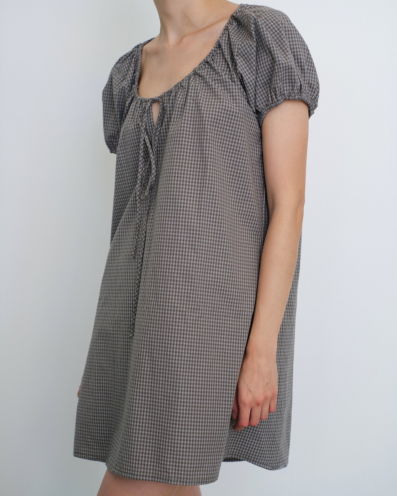 Close up view of Model wearing the Deiji Studios Capped Sleeve Mini Dress in Khaki Check Cotton Poplin